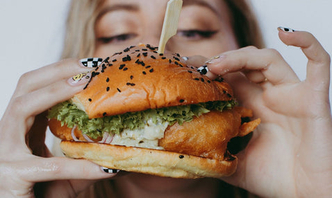 A person holding a burger form Eagle Bay Brewing Co