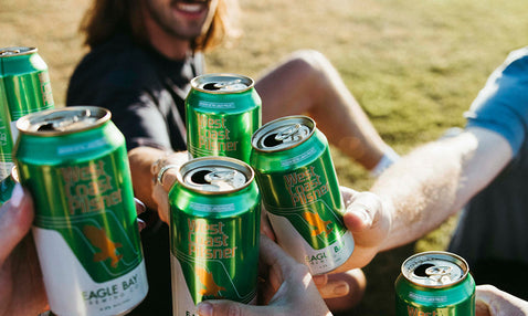 Eagle Bay Brewing Co people performing a cheers with the West Coast Pilsner cans