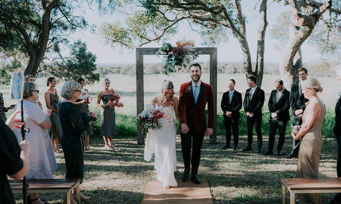 Just married couple walking back down the aisle together at a rustic wedding venue in Eagle Bay