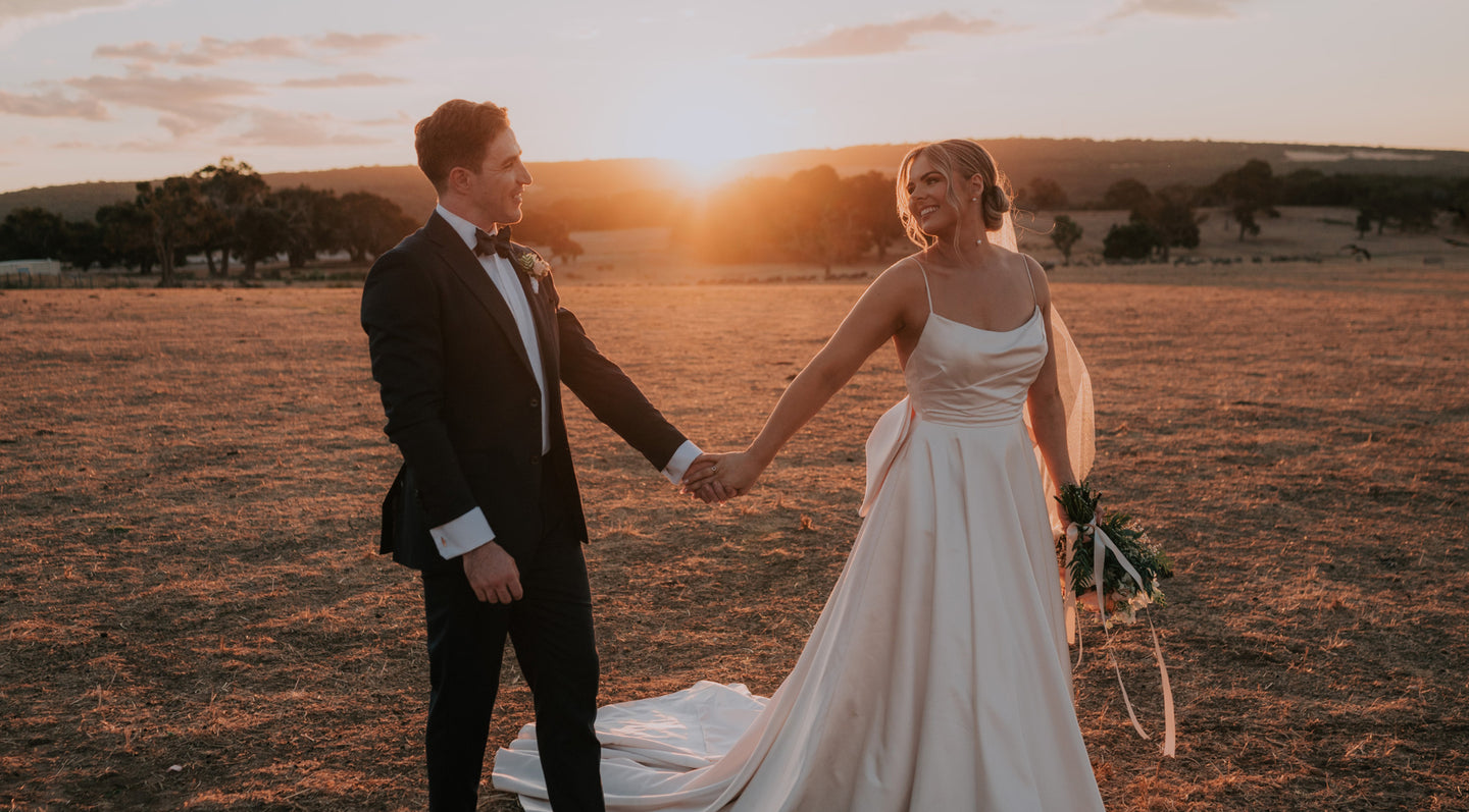 Married couple holding hands after their wedding ceremony at Eagle Bay Brewing Co in the farm.